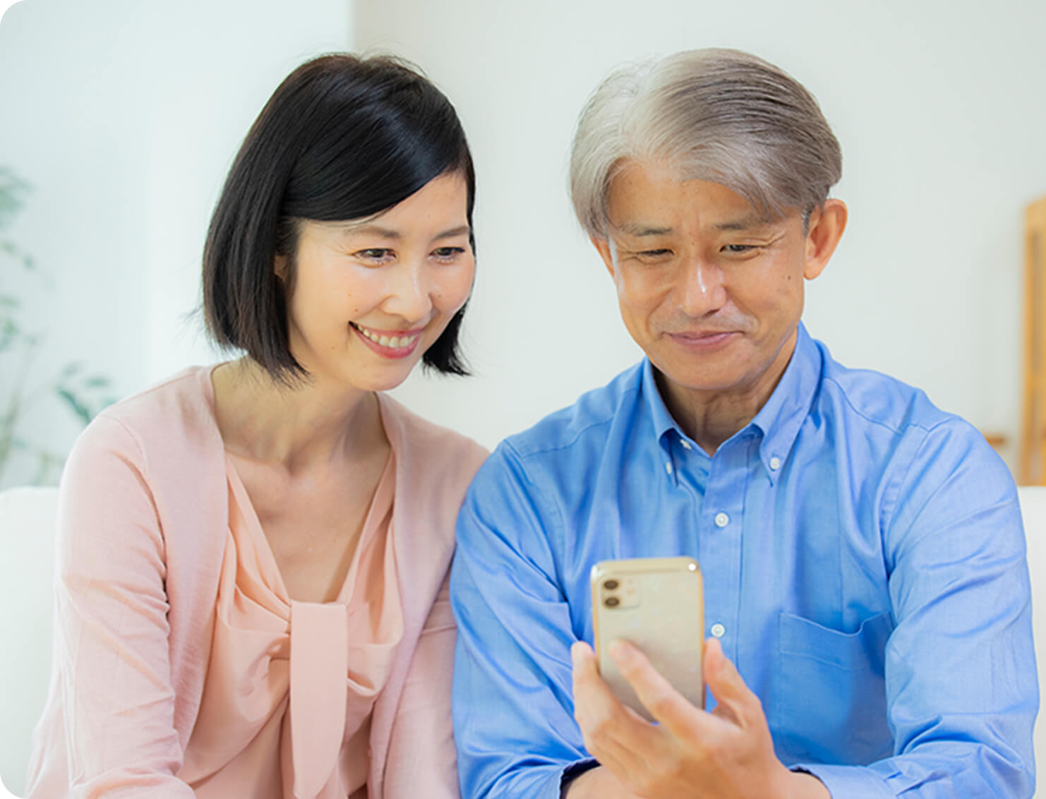 年配の夫婦がスマートフォンを使用して見守っている様子